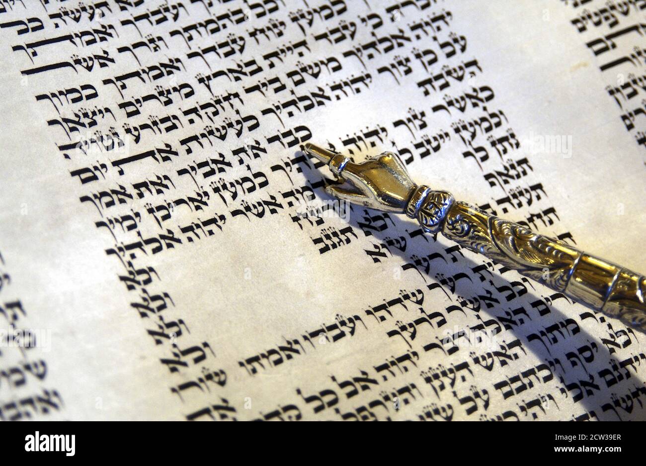 Judaism The yad points to Honour your Father and Mother part of the 10 Commandments in the Torah reading Stock Photo