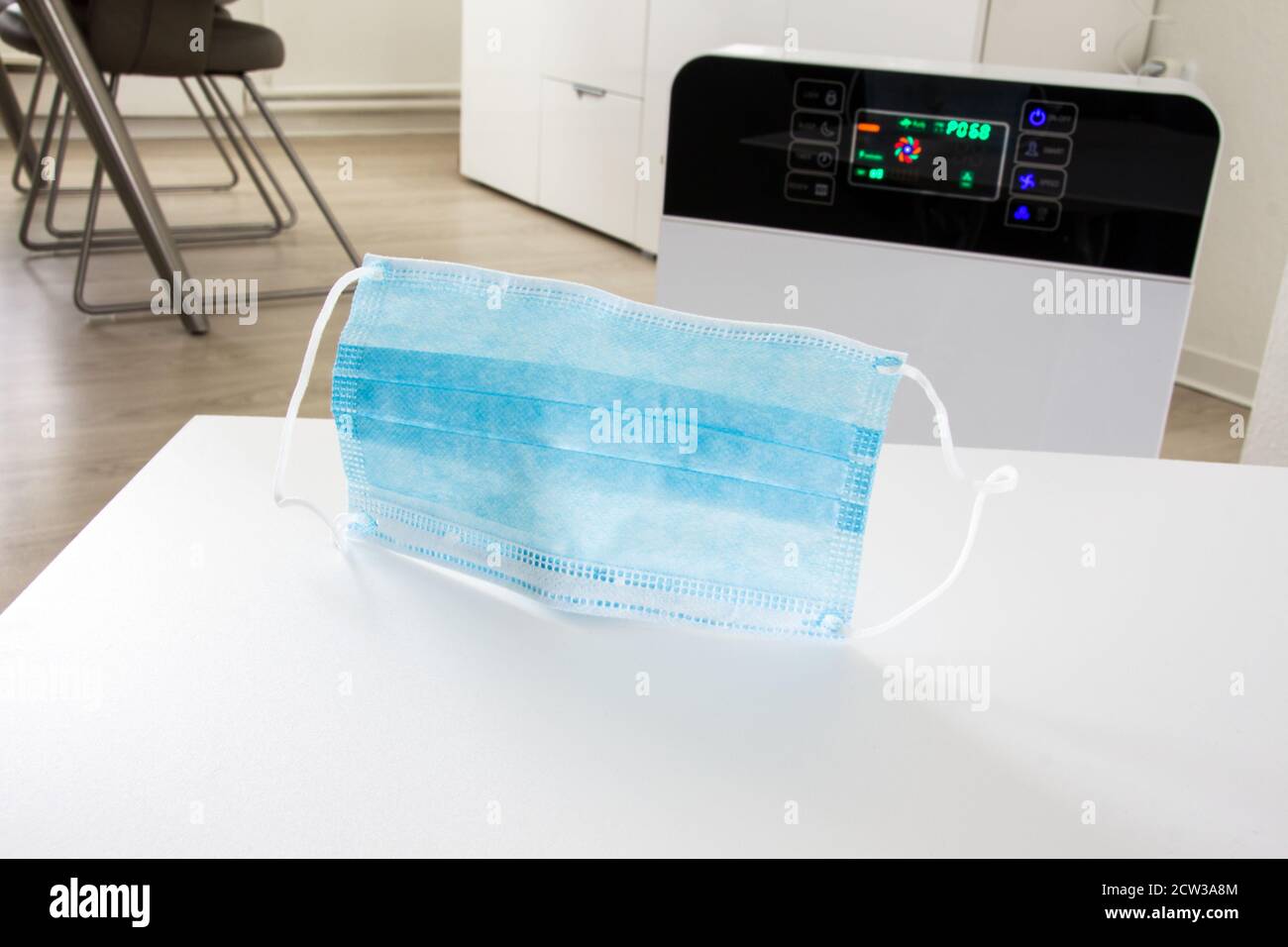 Air purifier in a living room with hepa filter and disposable medical mask Stock Photo