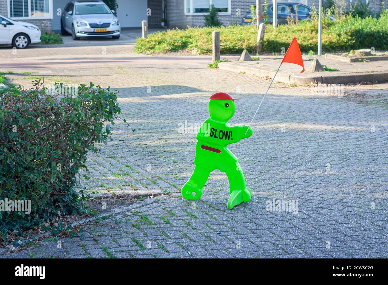 Fluorescent figure with cap and flag to warn traffic in a street for children playing and to limit speed. Stock Photo