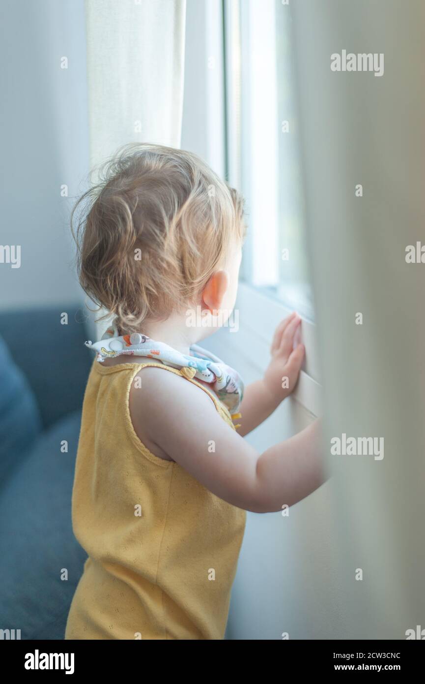 Baby looking through window Stock Photo Alamy