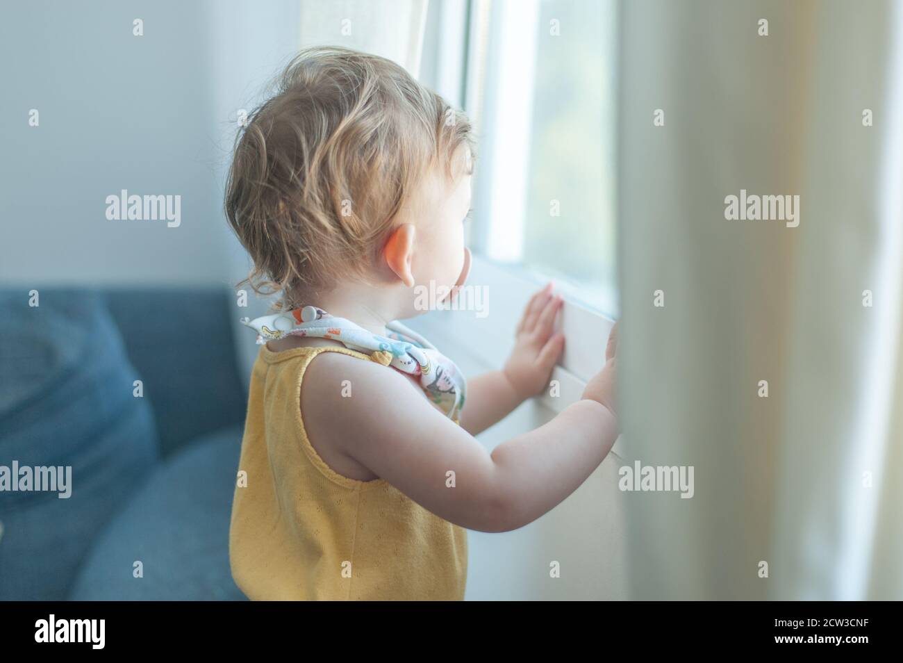 Baby looking through window Stock Photo Alamy