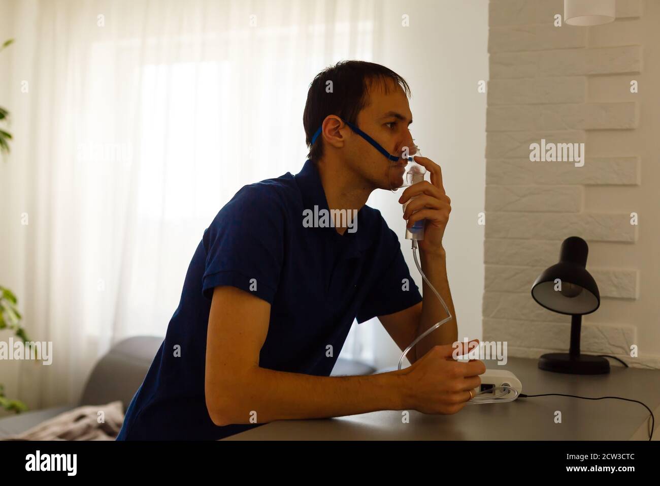 Portrait Of Young Man Inhaling Through Inhaler Mask Stock Photo - Alamy