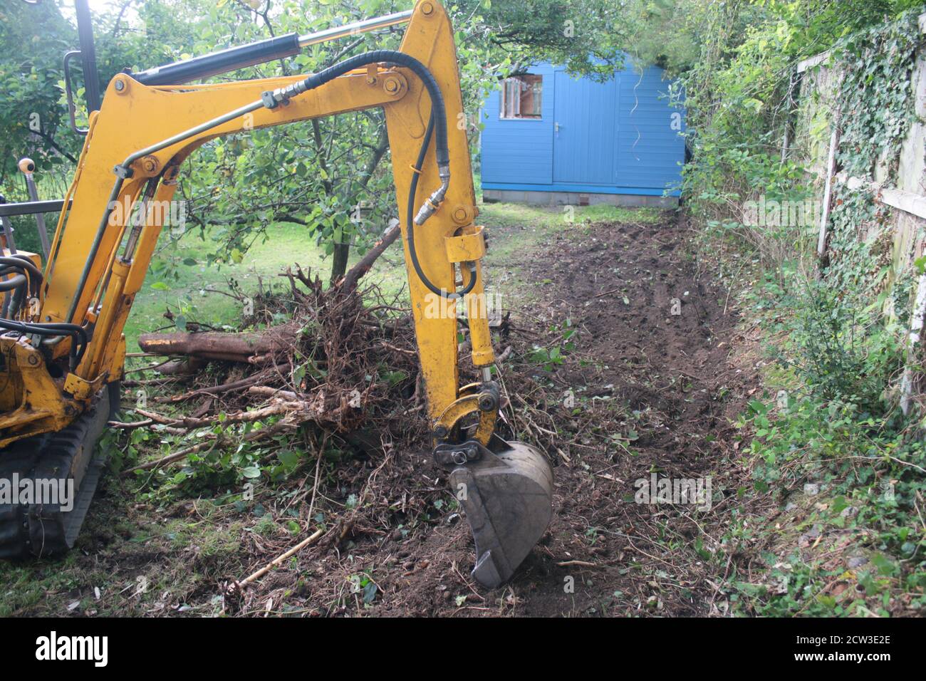 Yellow digger heavy motor machinery with digging arm moving earth, re