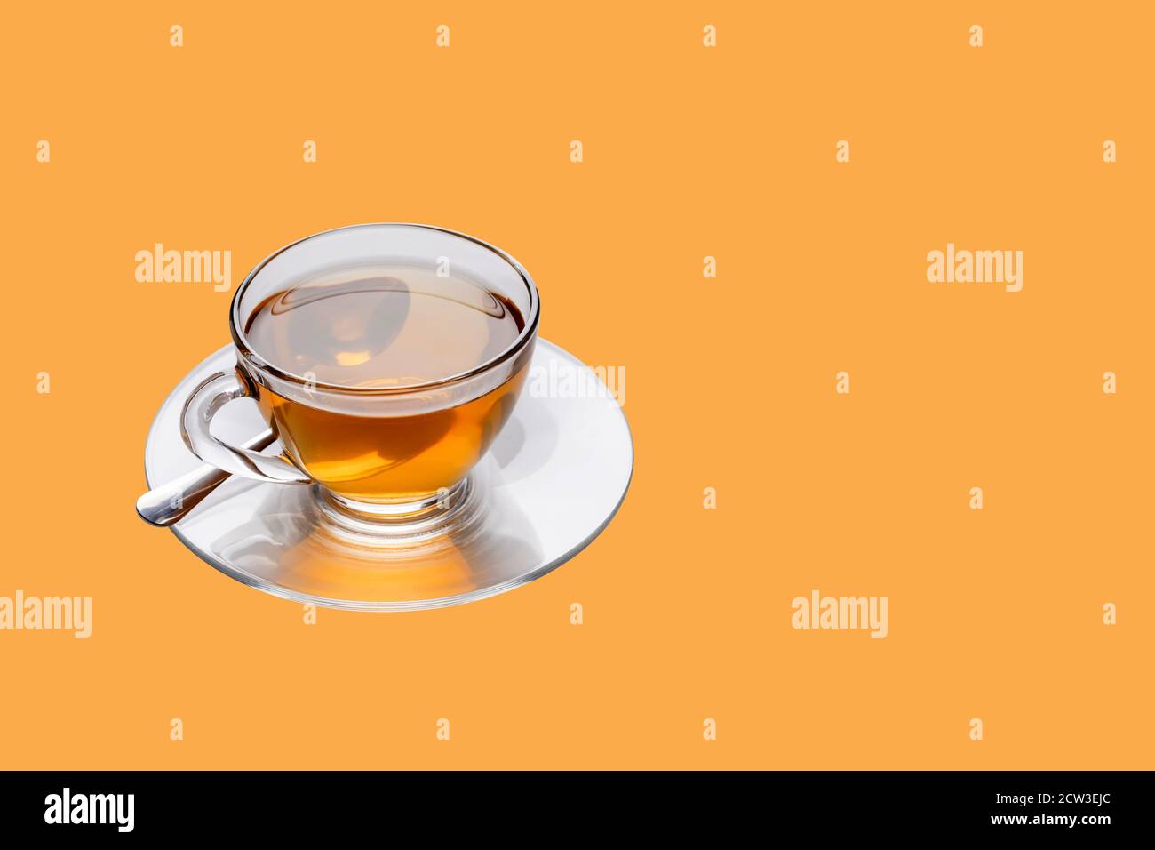 A cup of freshly brewed hot tea on the light orange background with a ...