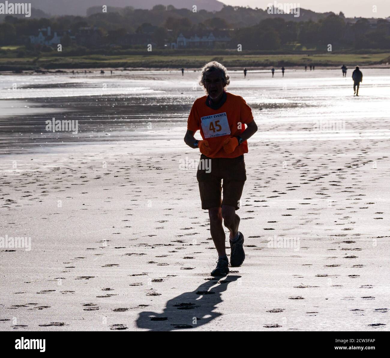 East Lothian, Scotland, United Kingdom, 27th September 2020. Scurry running event: Runners take part in a fun running event from Yellowcraig beach to North Berwick and back on a beautiful sunny Autumn morning. An older male runner on Broadsands beach Stock Photo