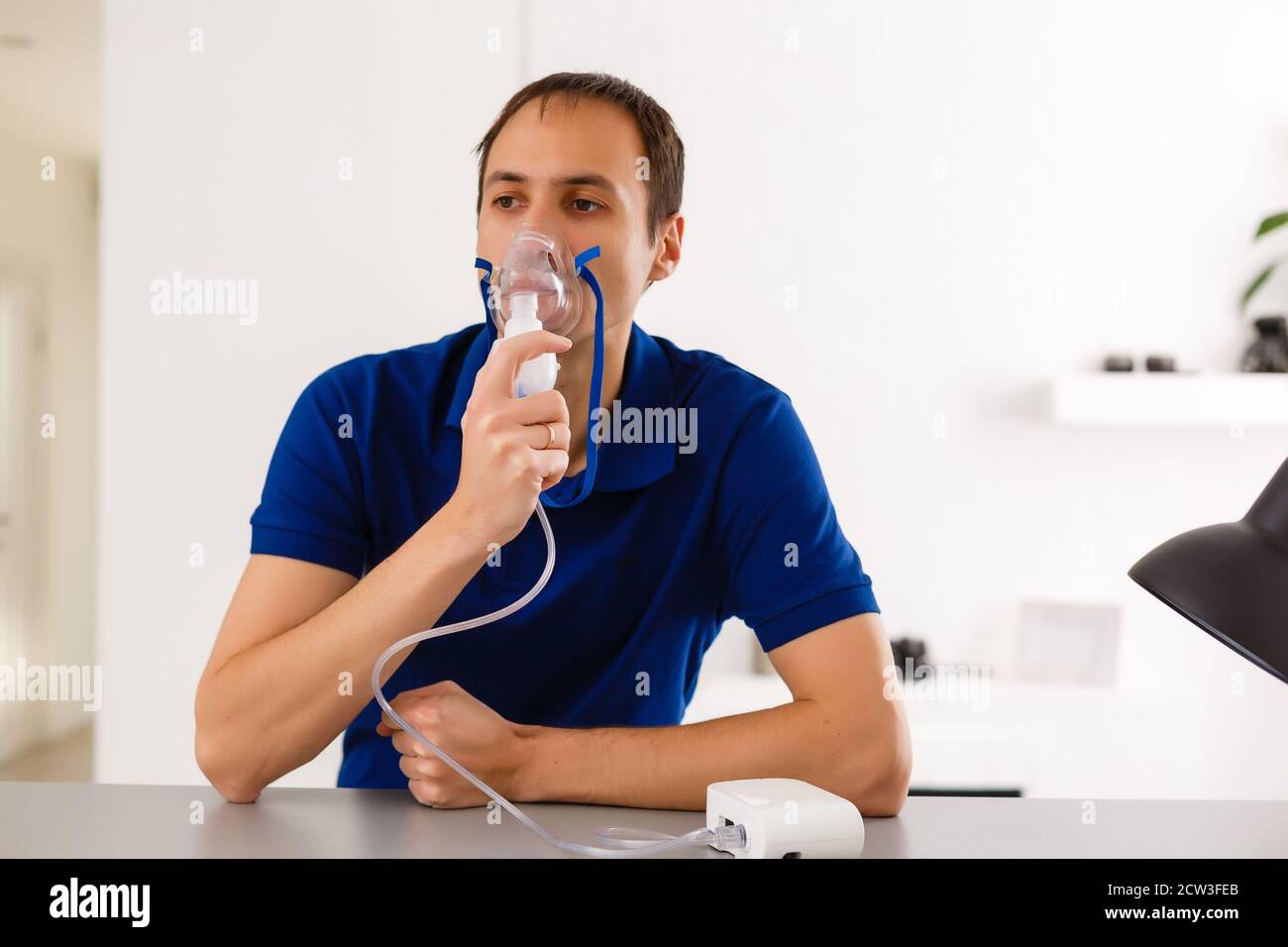 Portrait Of Young Man Inhaling Through Inhaler Mask Stock Photo - Alamy