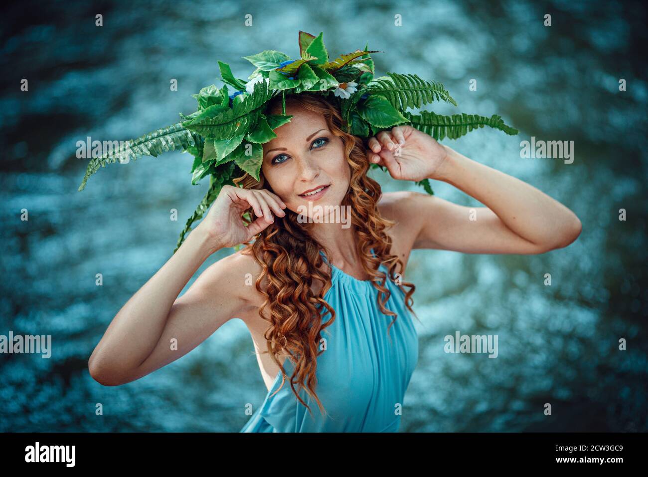 a beautiful young woman with red hair and a wreath of flowers and fern ...
