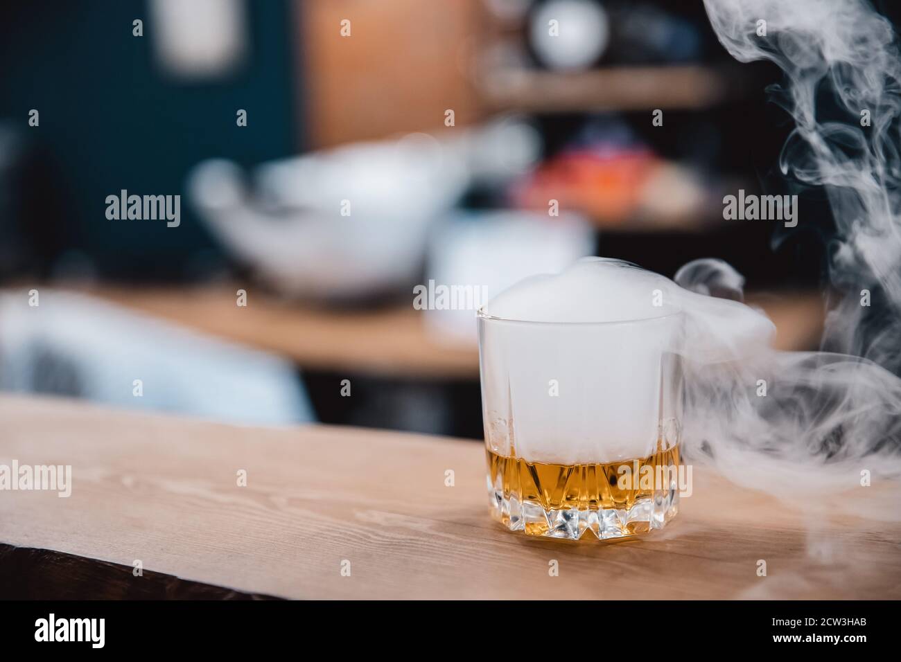 Glass with smoke brown whiskey stands on bar counter Stock Photo