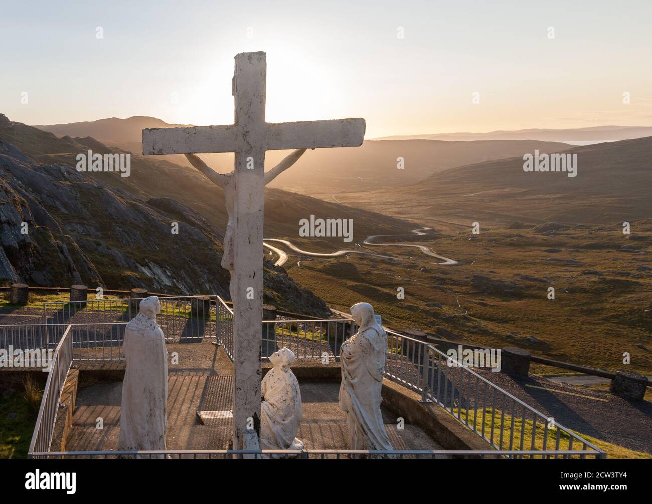 Healy Pass, Cork, Ireland. 27th September, 2020. Early morning sunlight begins to illumante the statue of the crucifixion on the peak of the Caha mountain range at the Healy Pass in West Cork, Ireland. - Credit; David Creedon / Alamy Live News Stock Photo