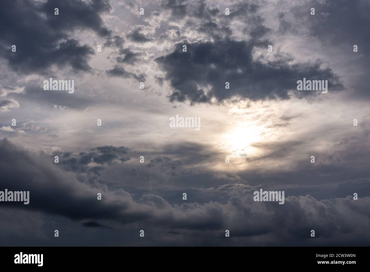 Grey high layered grey epic clouds with sun and sunlight on sky. Heaven cloudscape air view Stock Photo