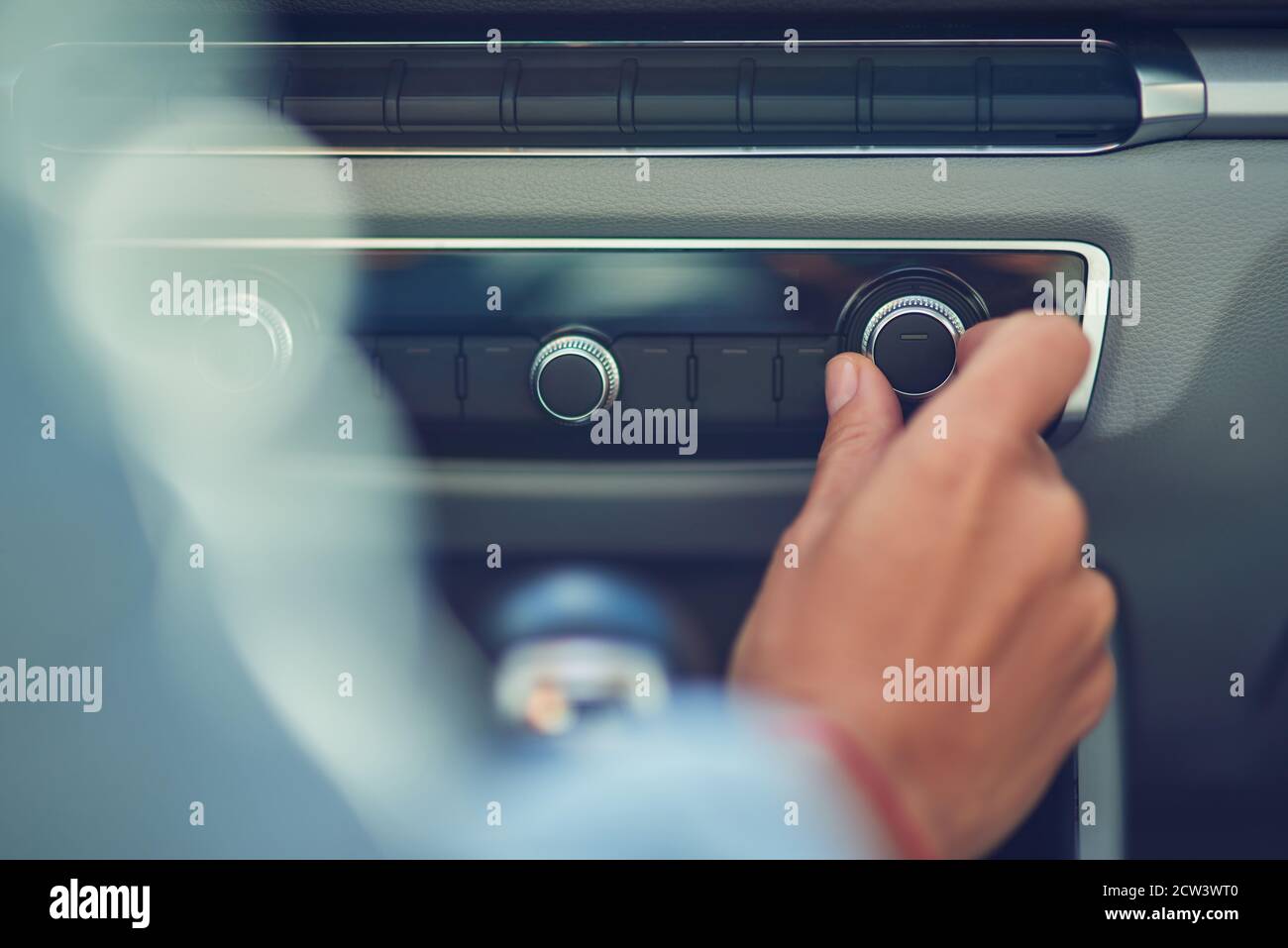 Listening music, cropped shot of a woman turning on radio while driving in the city, close up Stock Photo