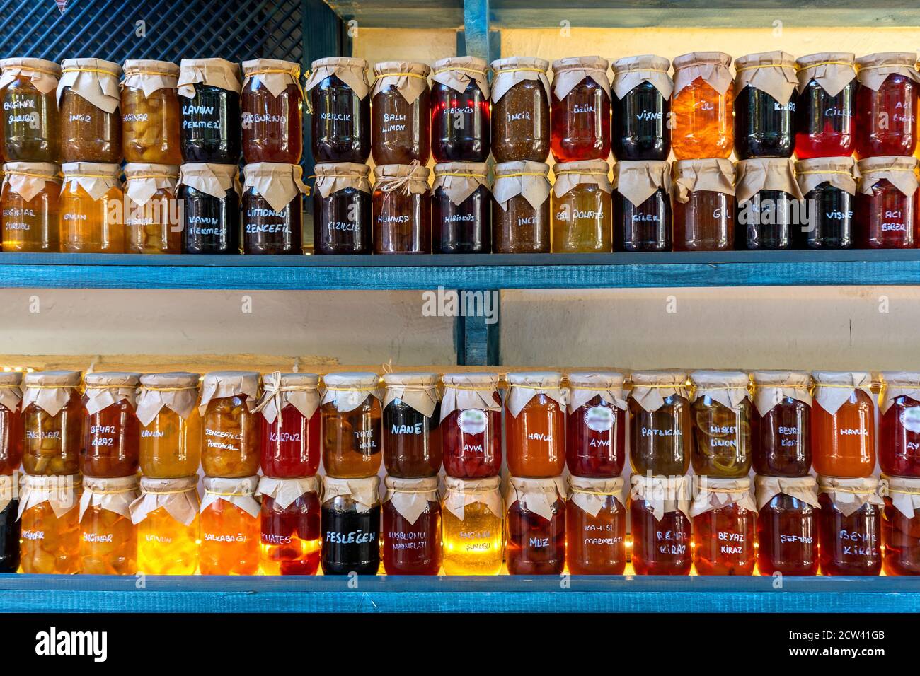 Colorful jams in glass jars. Translation "different fruit names” Stock