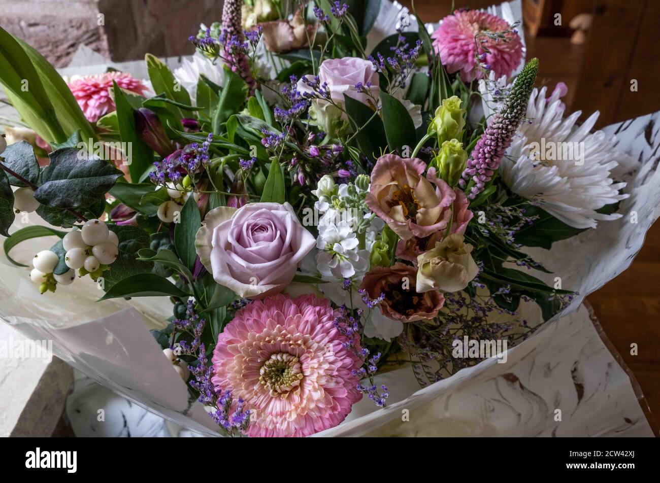Beautiful boquet of colourful flowers warpped in brown paper Stock Photo