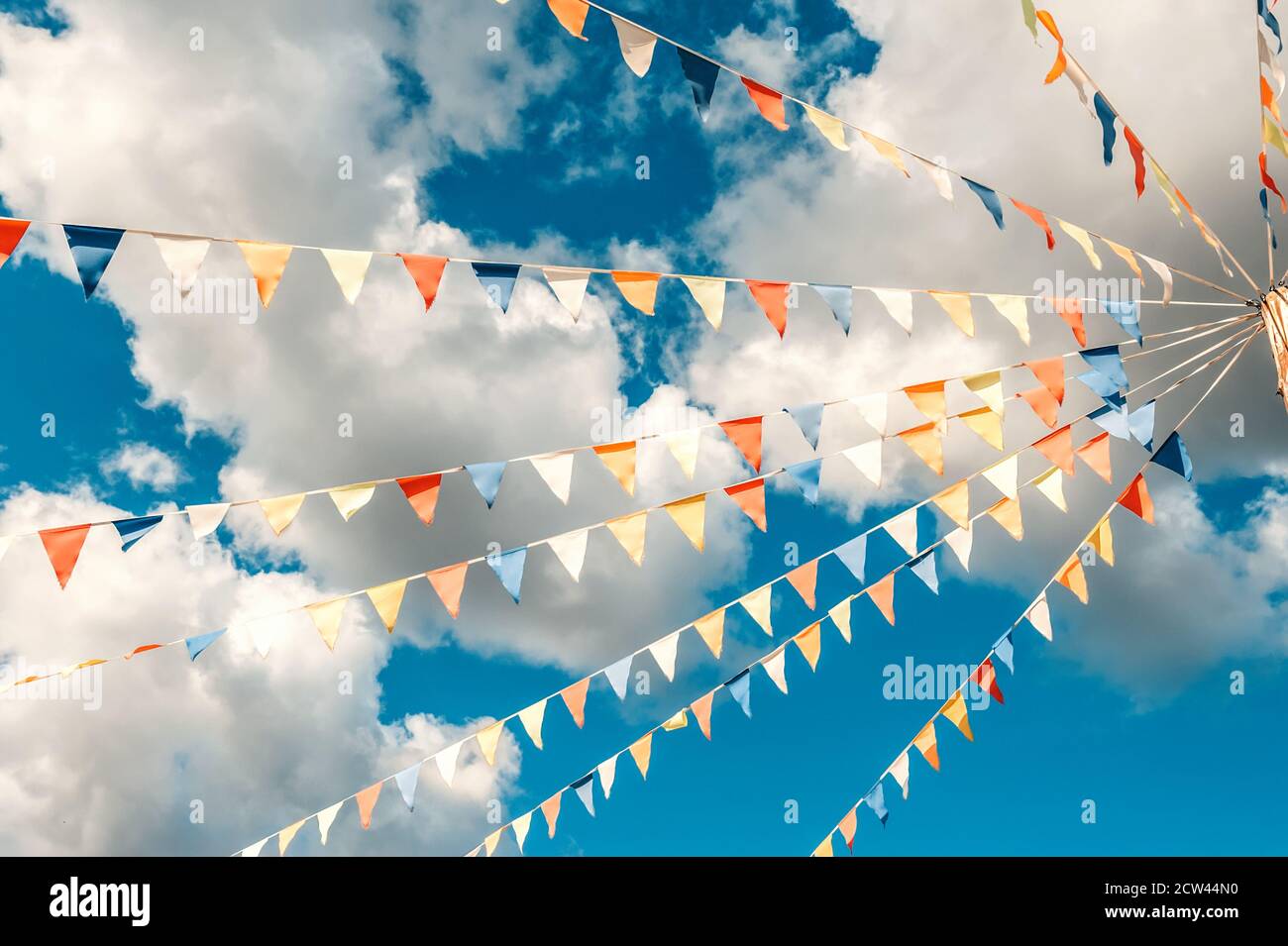 Colorful bright triangular Bunting flags on a blue sky background with ...