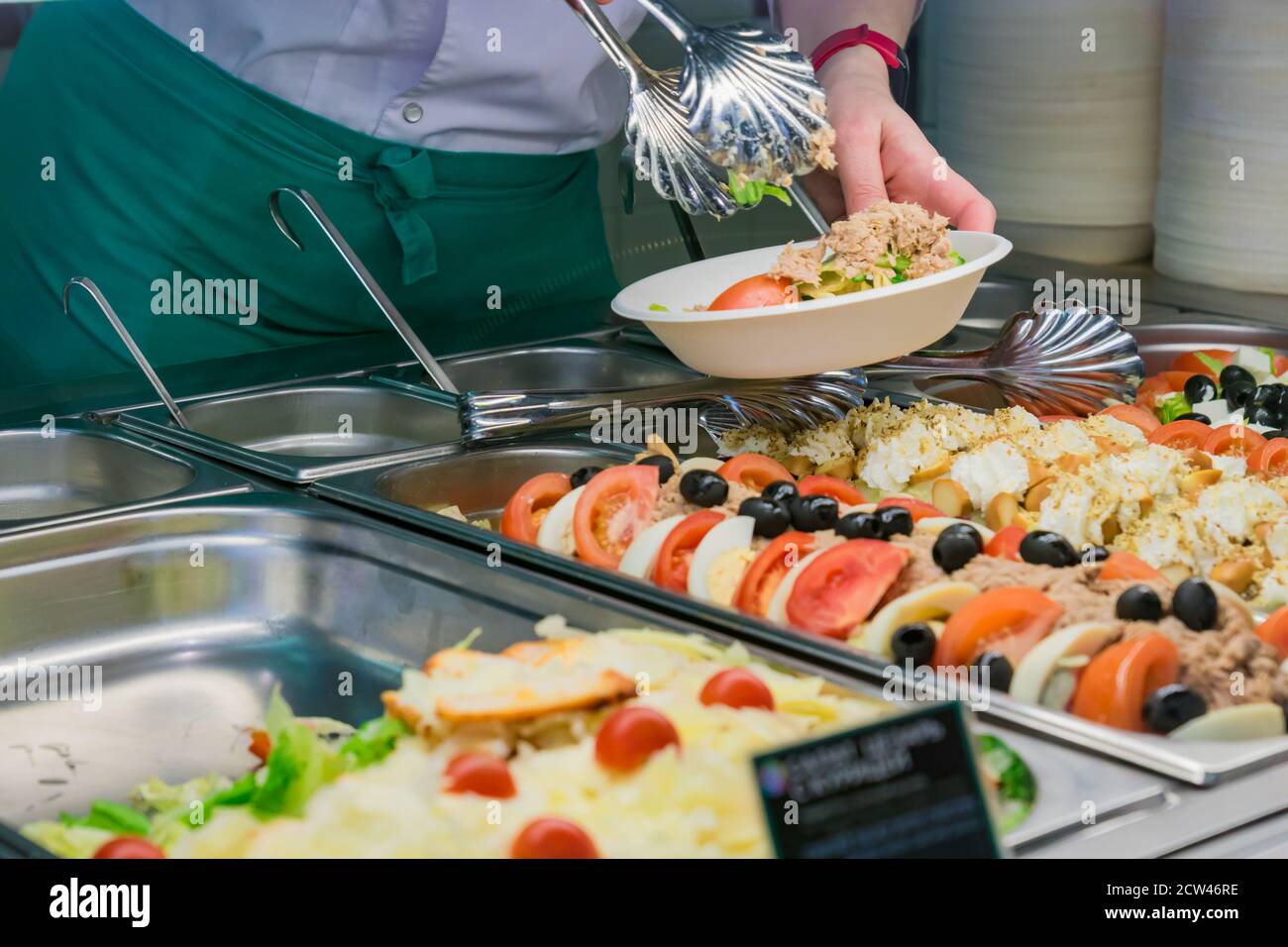 buffet selfservice food display human hand take plate and put a salad