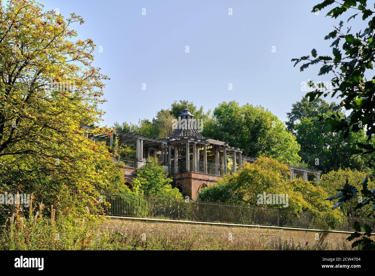 View of the Georgian arbour and beautiful autumn leaves at the Hampstead Pergola & Hill Gardens against blue sky. Stock Photo