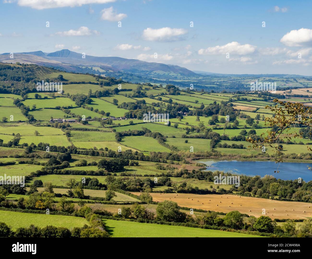 Llangors Lake or Llyn Syfaddan in the Black Mountains of Wales with Pen y Fan in the far distance Stock Photo