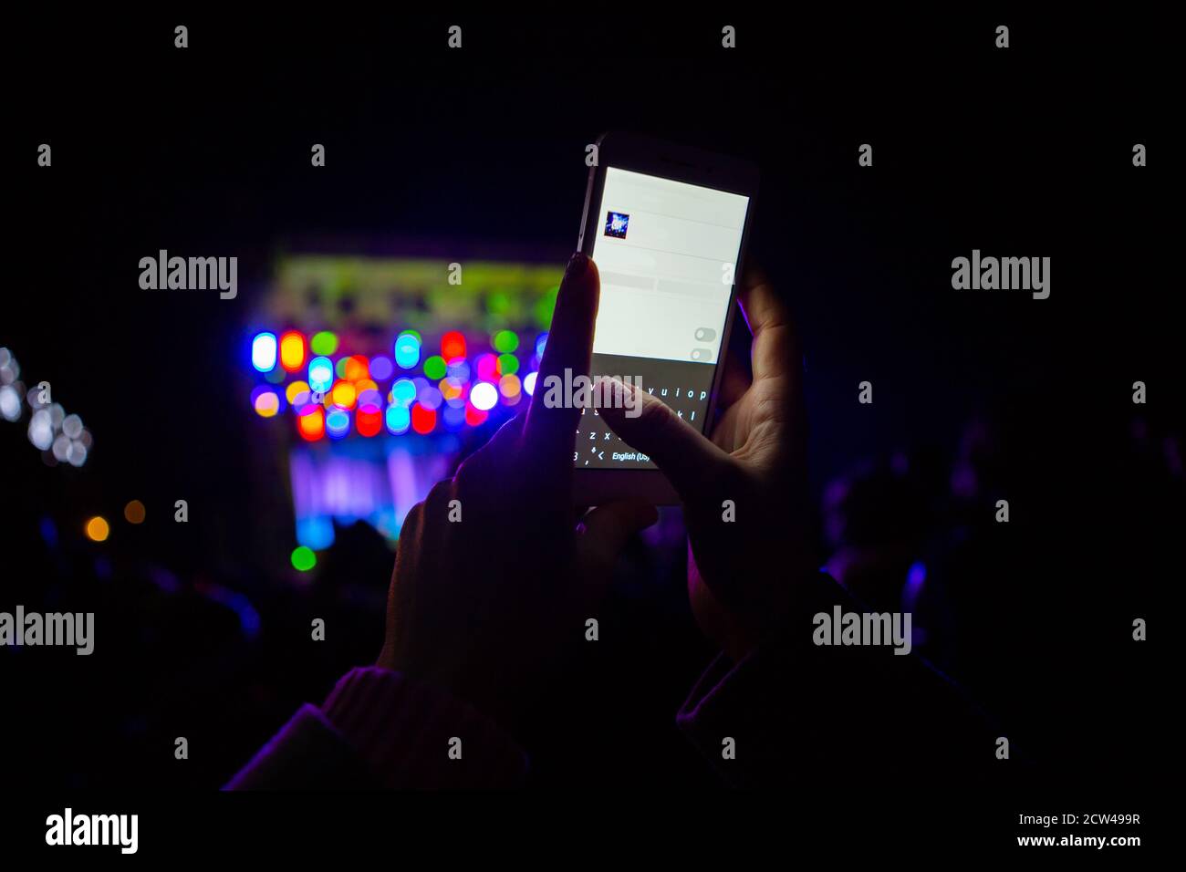 A girl is taking pictures of a street concert on the phone Stock Photo