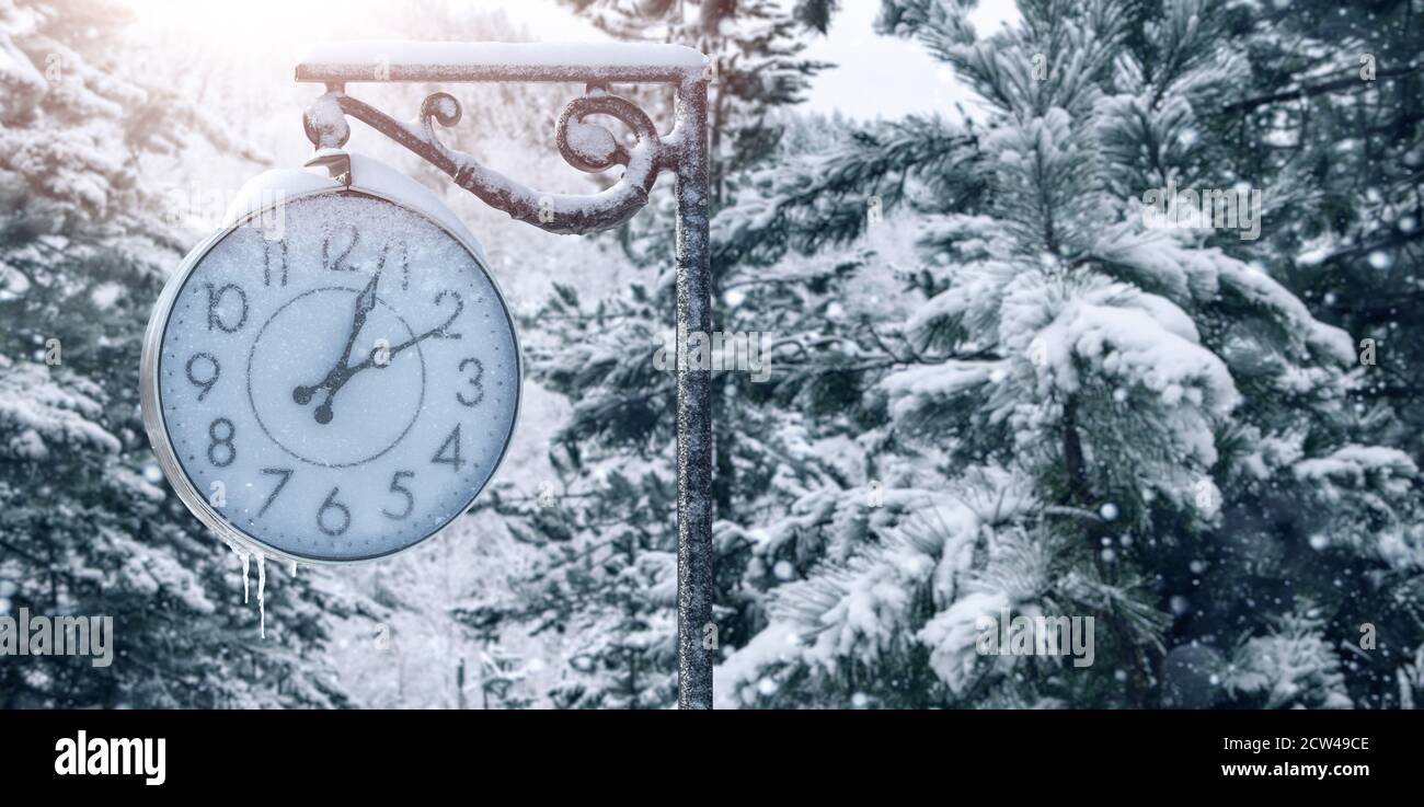 Street clock in winter. Change to winter time  Stock Photo