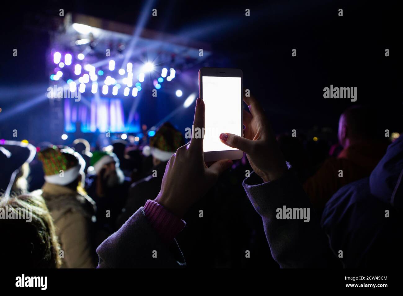 A girl is taking pictures of a street concert on the phone Stock Photo