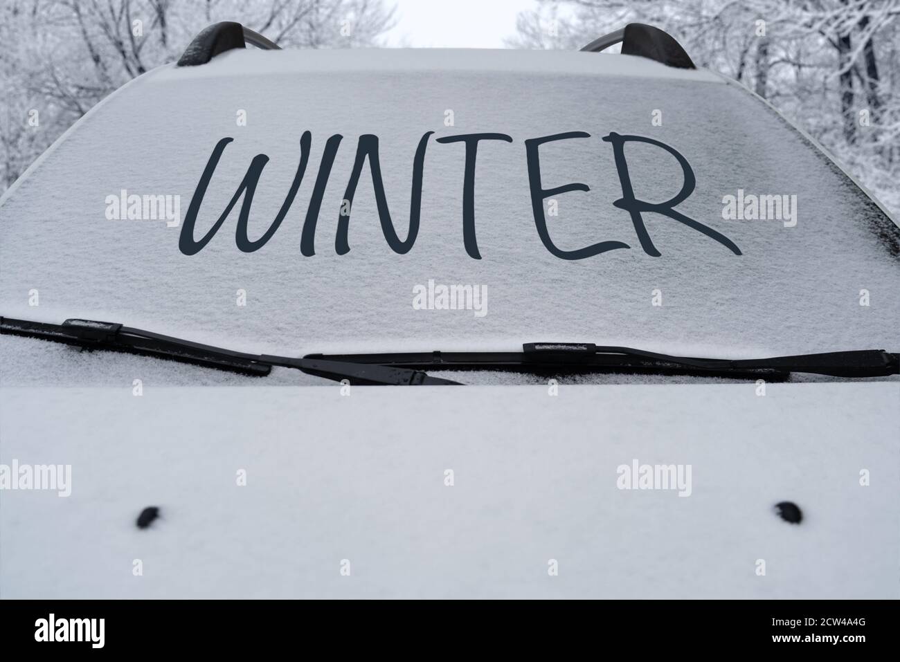 Parked car with snow on the windshield and the inscription Winter Stock Photo