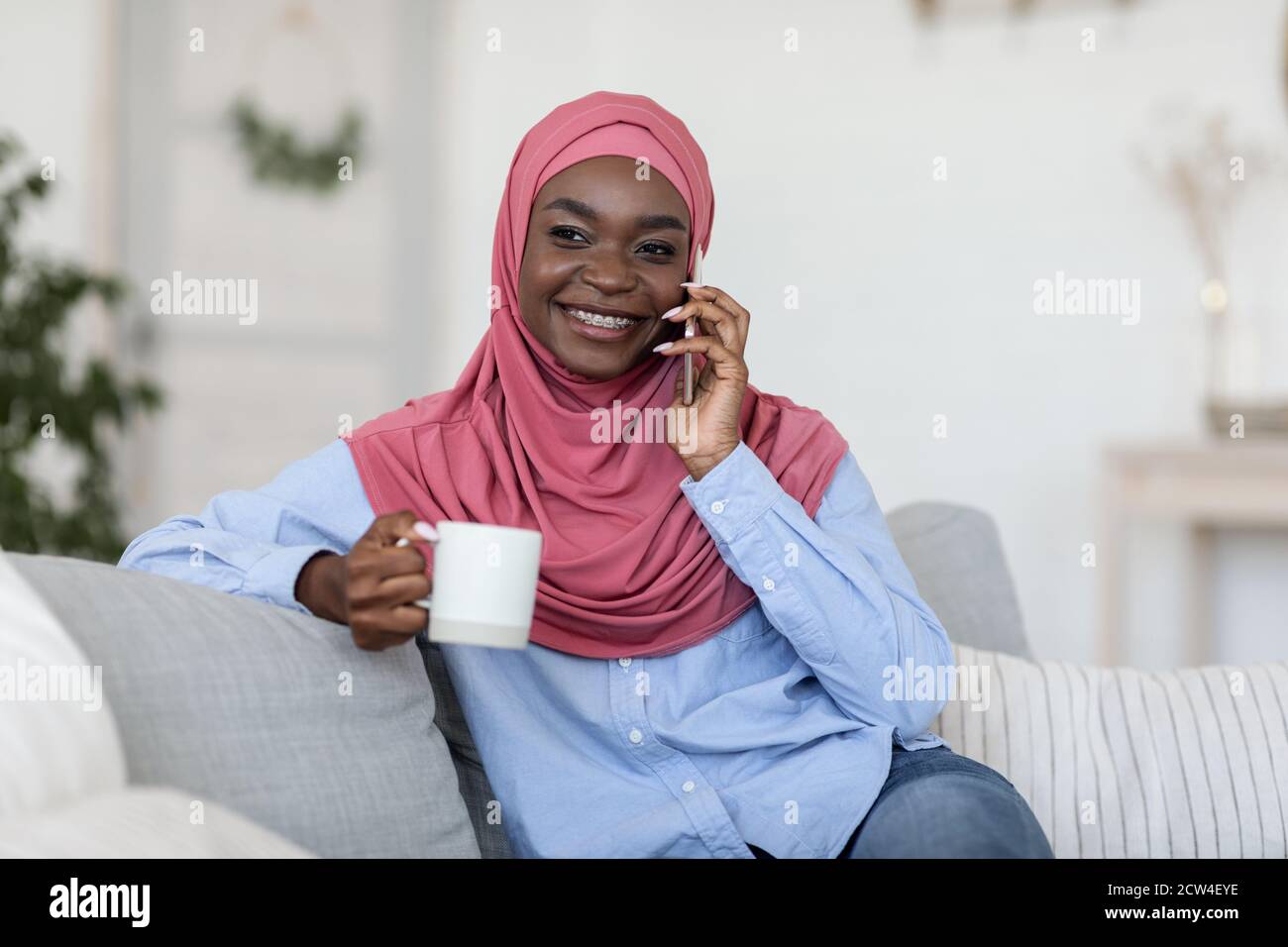 Free Time Leisure. Black Muslim Woman Talking On Phone And Drinking ...
