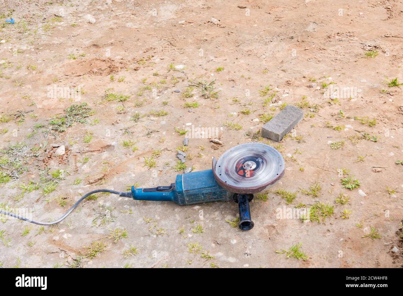 operating angle grinder on the ground. Stock Photo