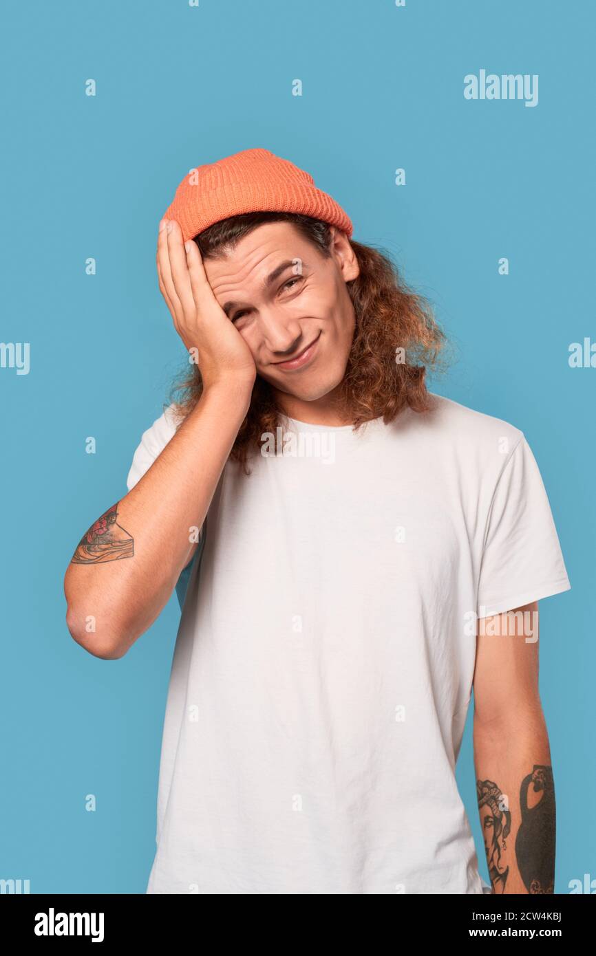 Young adult guy holding hand near face Stock Photo