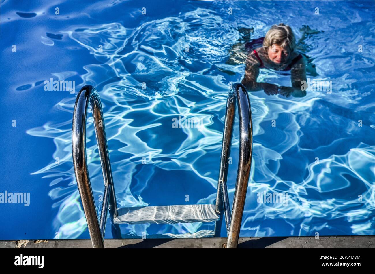 Woman swimming alone in a swimming pool Stock Photo