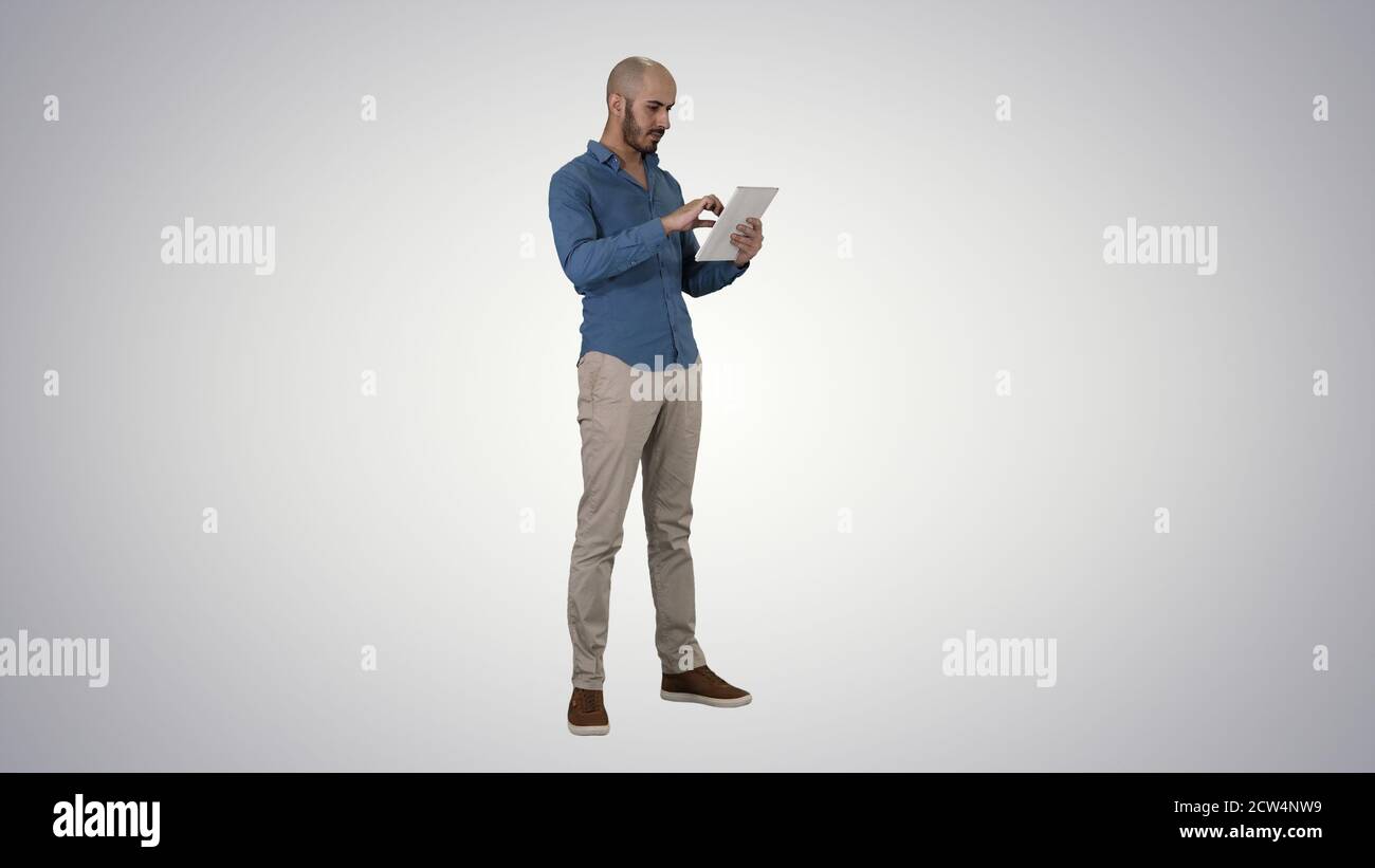 Handsome arabic business man using tablet on gradient background Stock Photo