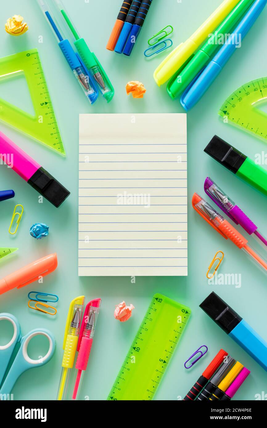 school and office items, colored pens, staples, felt-tip pens, set squares,  a blank notebook for your own text in the center Stock Photo - Alamy