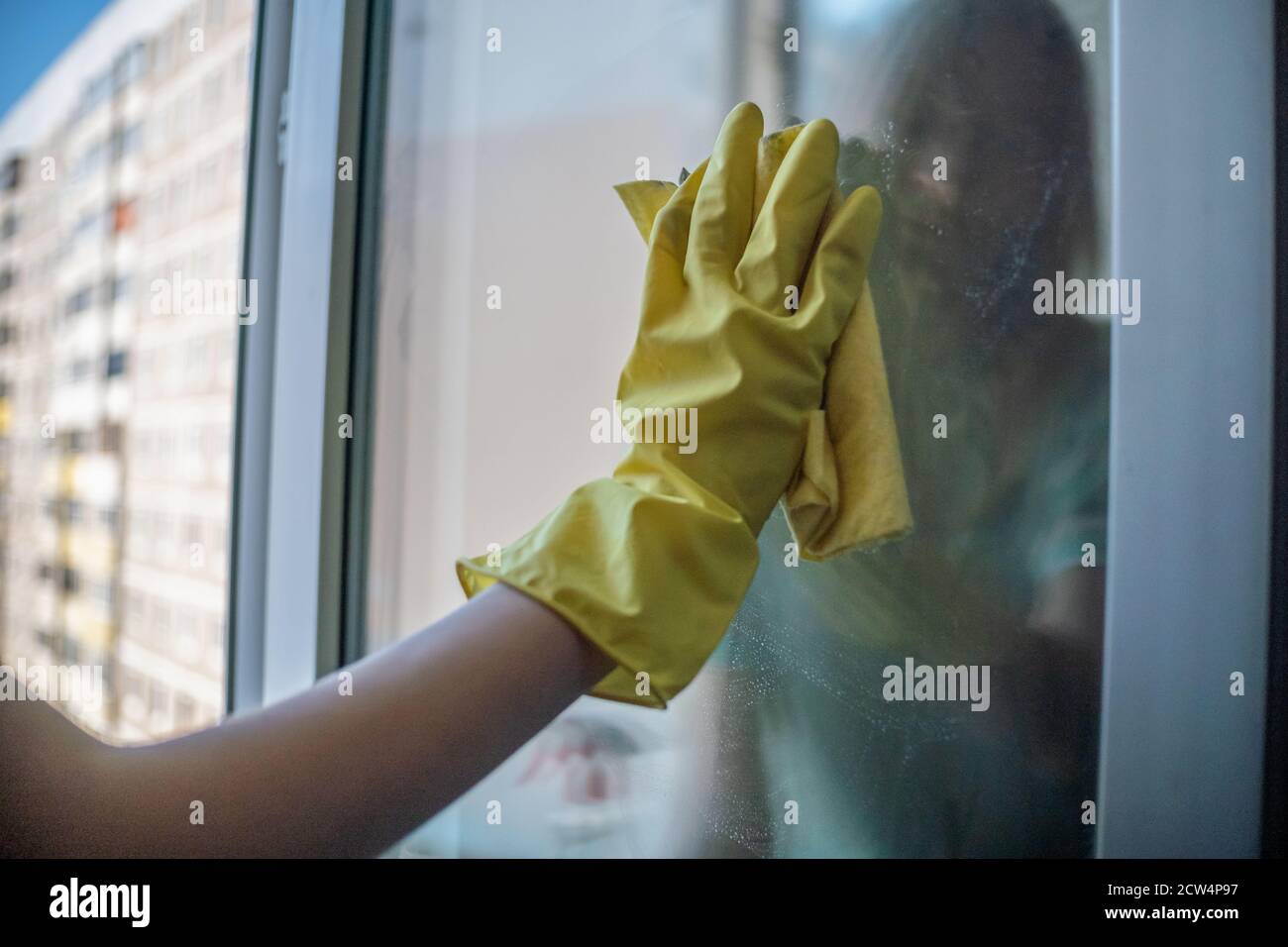 Female Hand In Yellow Gloves Cleaning Window Pane With Rag And Spray Detergent Cleaning Concept