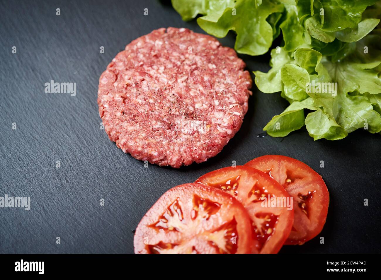 beef for burger on the table with lettuce onion and bread Stock Photo