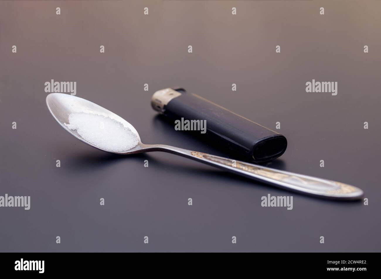 spoon with drugs for heroin cooking on dark table. Drug addiction concept Stock Photo