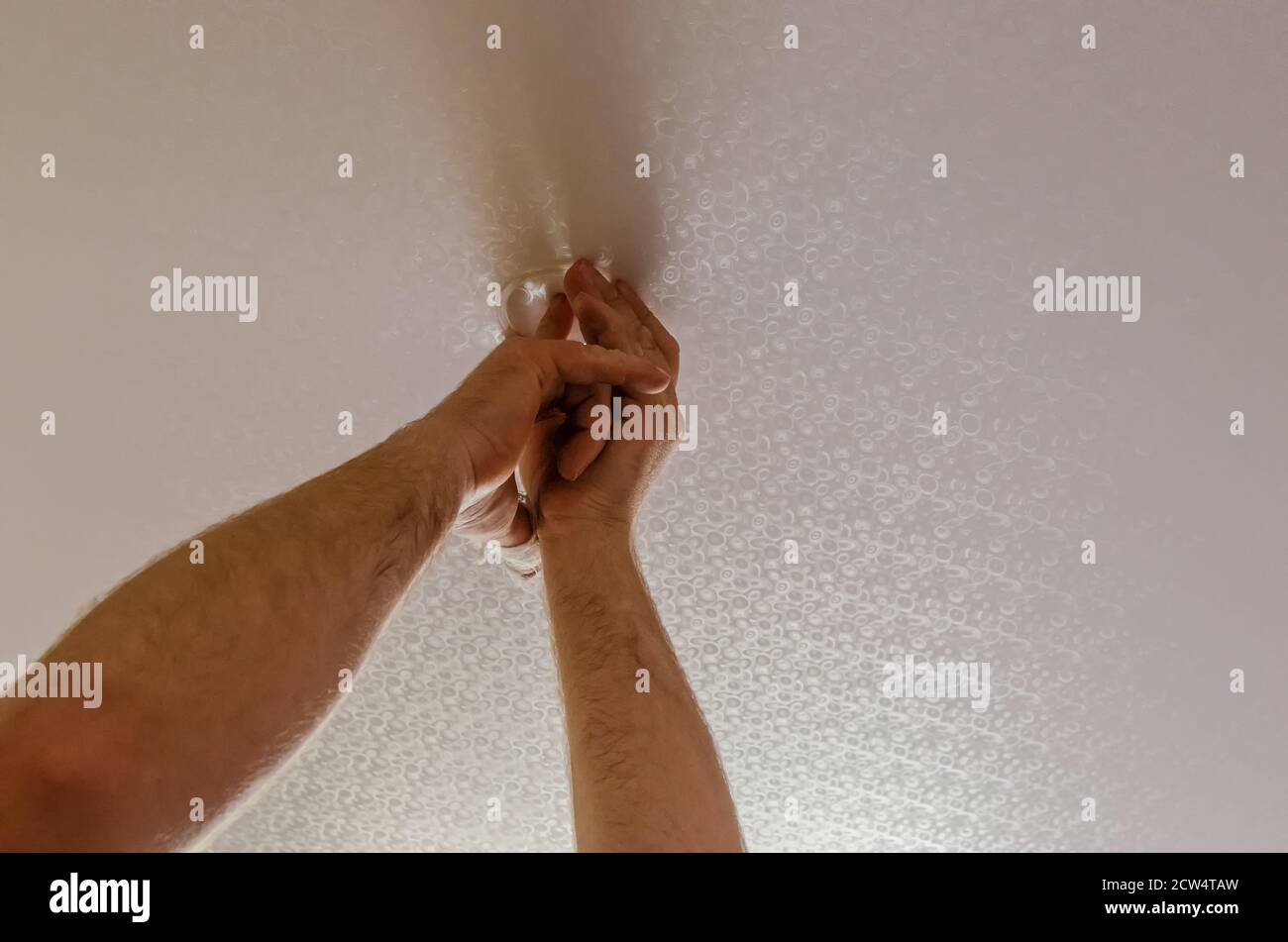 cutting a hole for a spotlight on a stretch ceiling. installation of spotlights on stretch vinyl