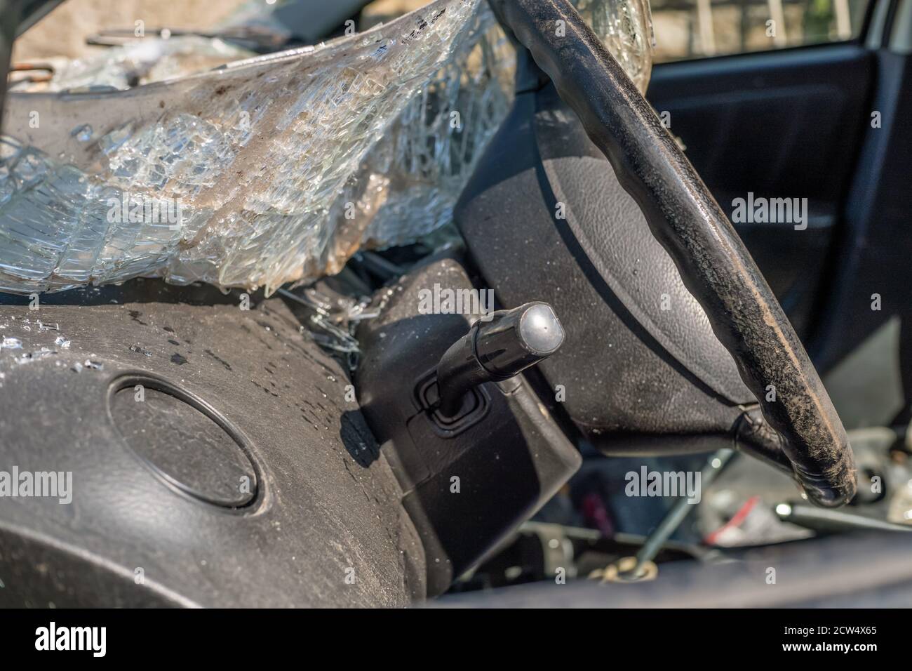 Completely destroyed car. The windshield is broken and lies inside the car Stock Photo