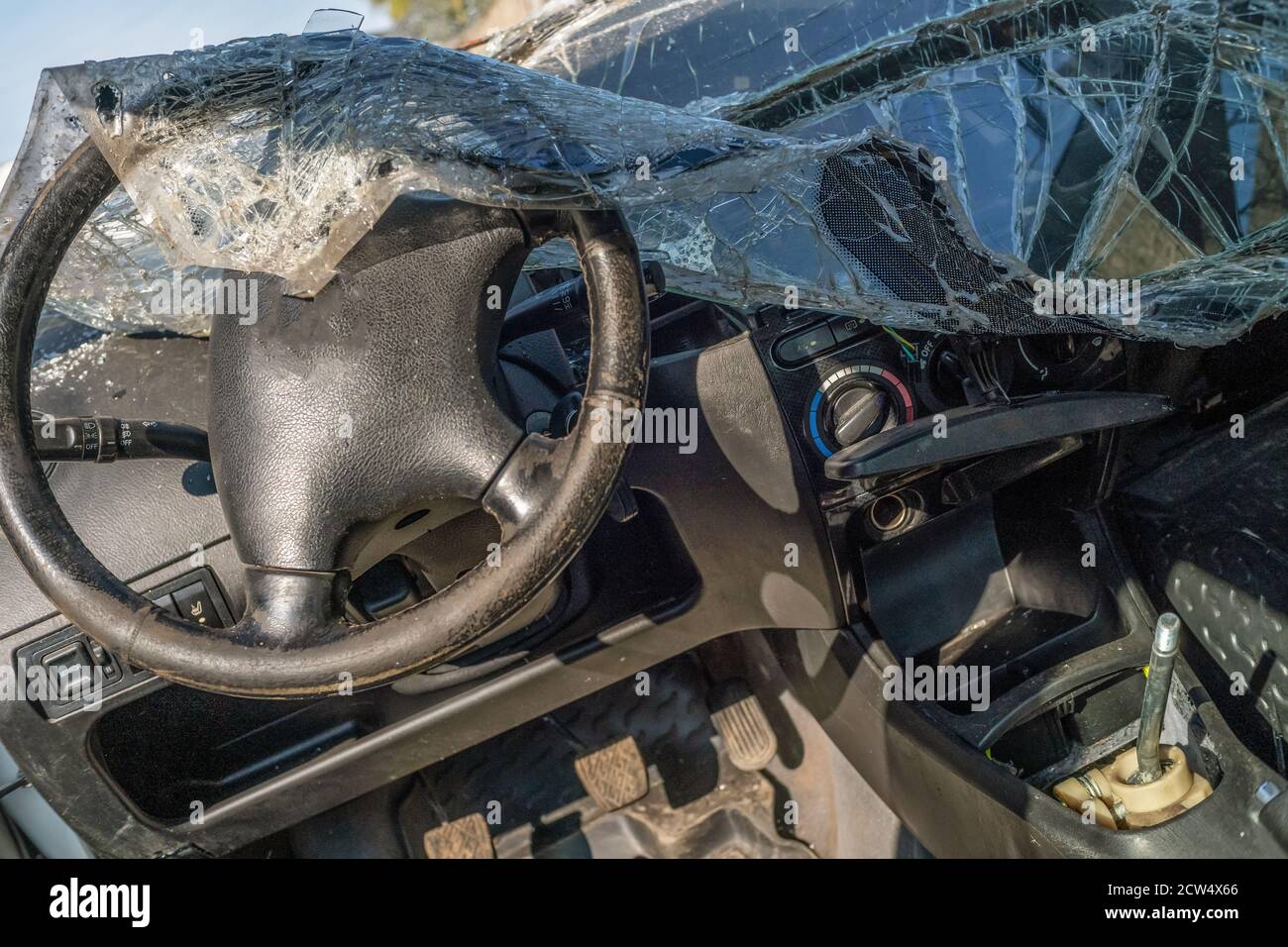 Completely destroyed car. The windshield is broken and lies inside the car Stock Photo