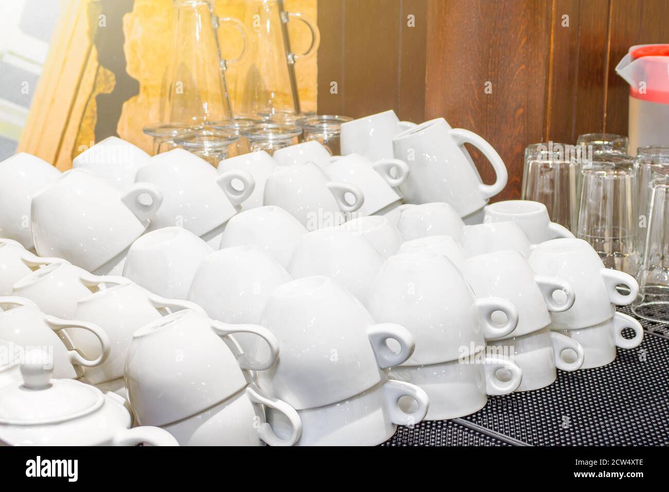 Lot of white clean white cups lie on the rubber mat in the restaurant after washing Stock Photo