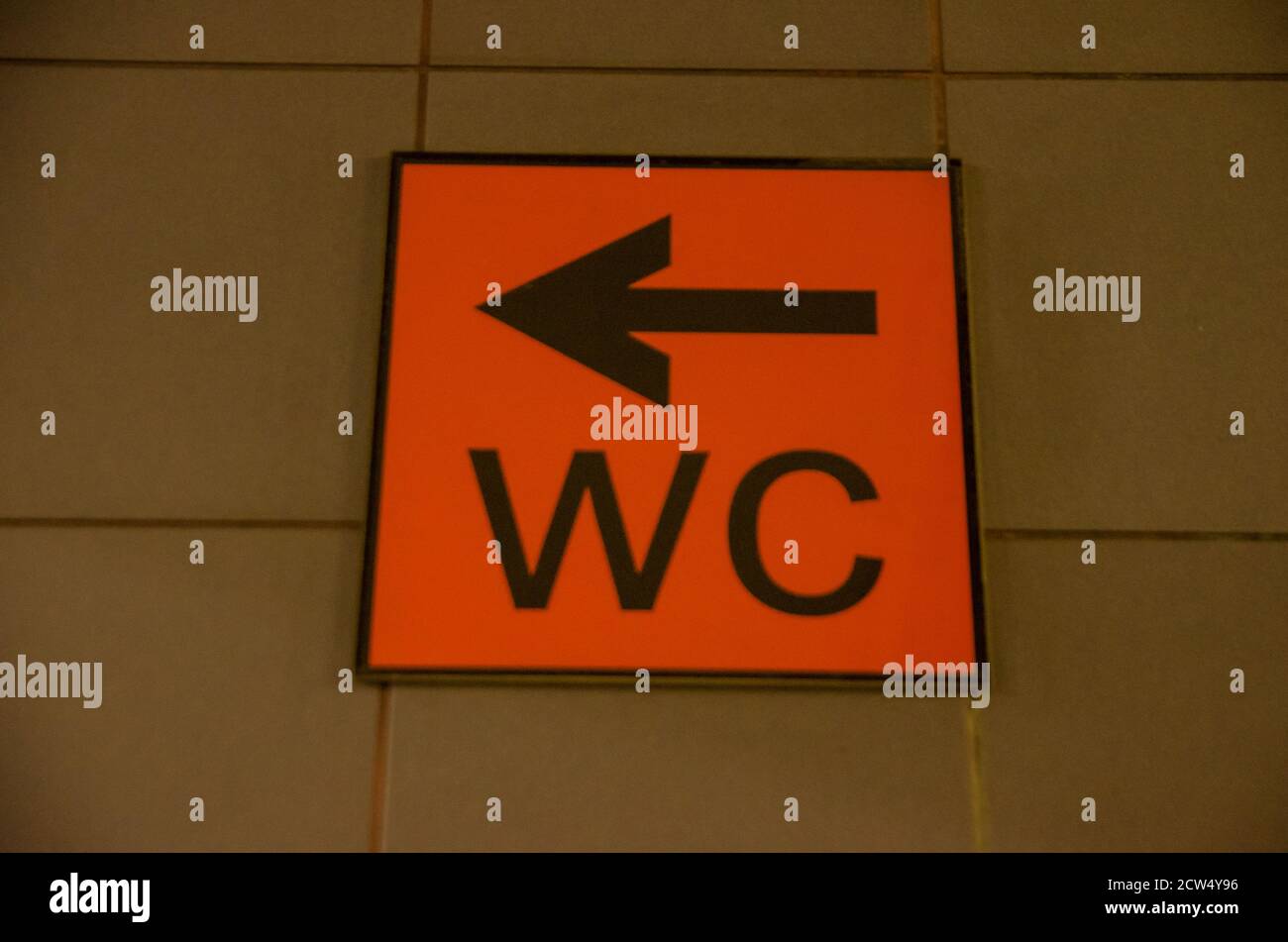 Toilet orange sign with an arrow written Stock Photo Alamy
