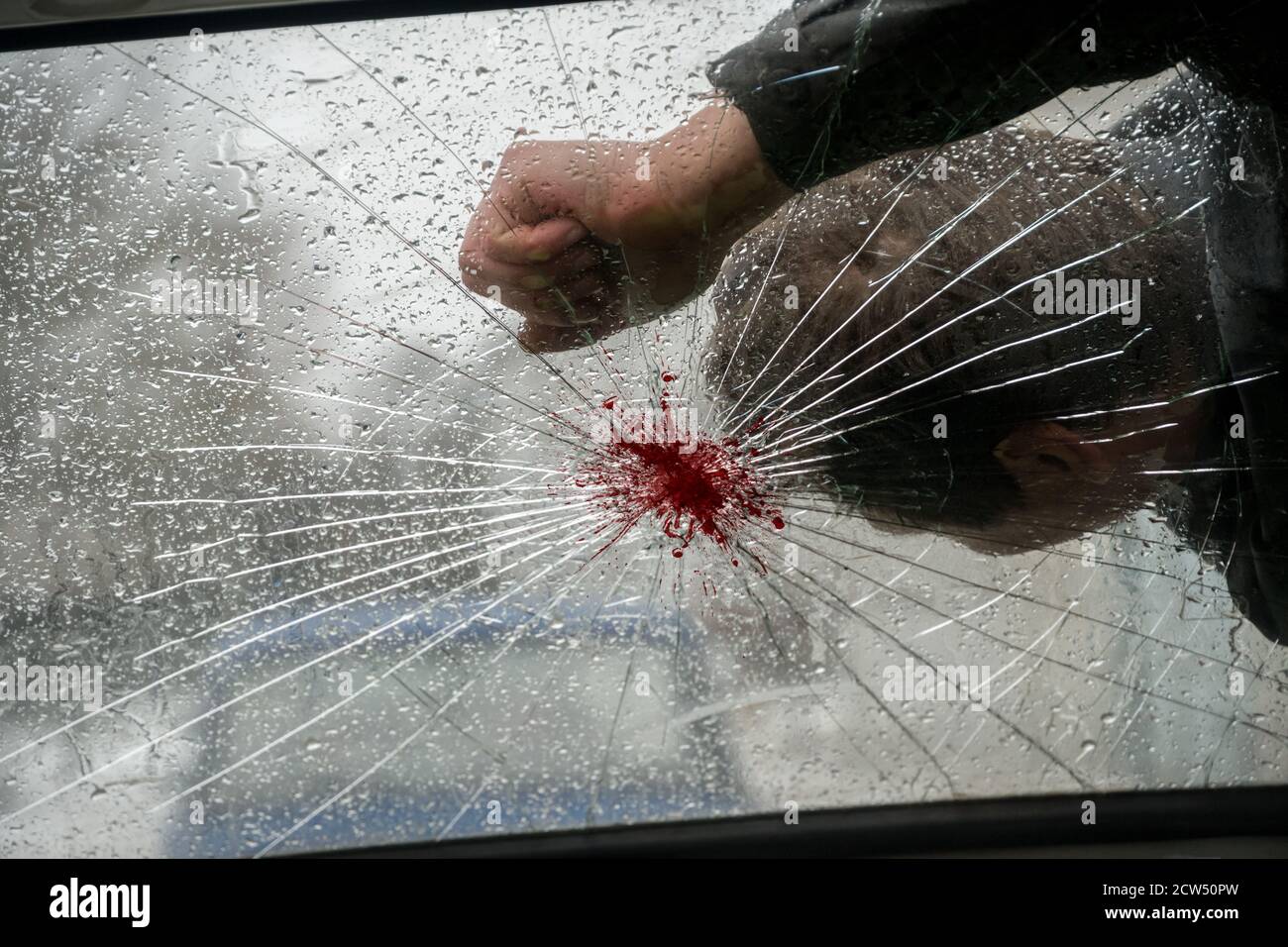 Dead man with blood on the broken windshield of the car. A car hit a man. Stock Photo