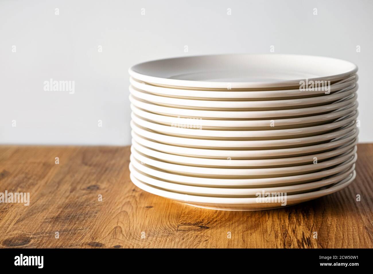 many Clean white plates dishes kitchenwear on table Stock Photo