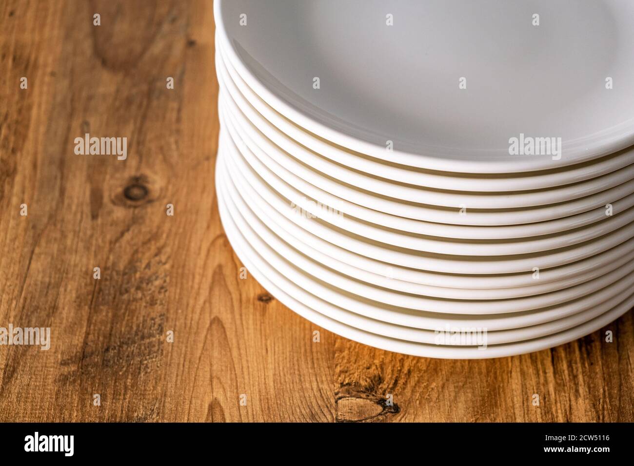many Clean white plates dishes kitchenwear on table Stock Photo