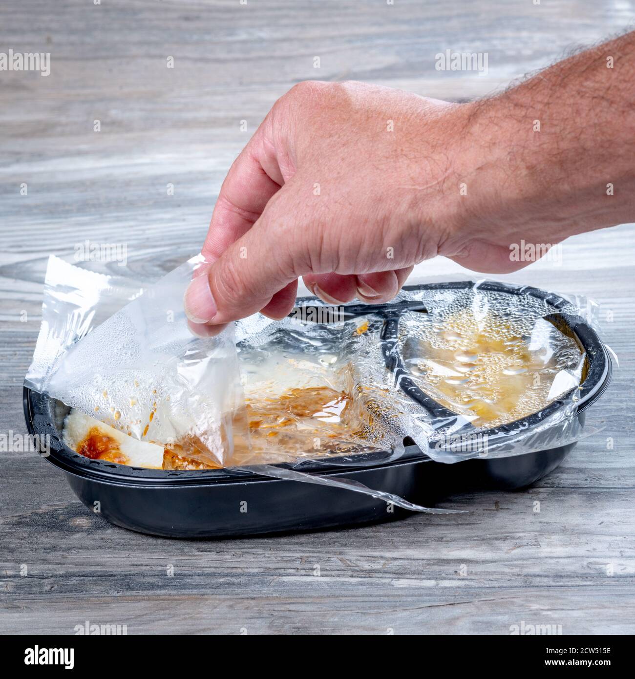 Hot Meatloaf TV dinner pull plastic cover off Stock Photo