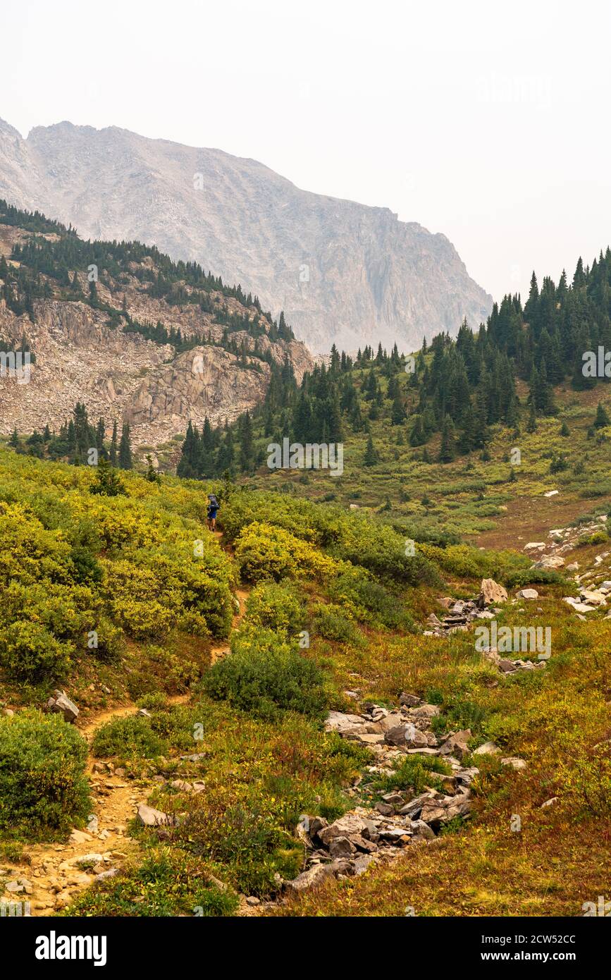 View of the Four Pass Loop trail leading up to Snowmass Mountain and Trail Rider Pass near Aspen, Colorado during a hazy summer day due to forest fire Stock Photo