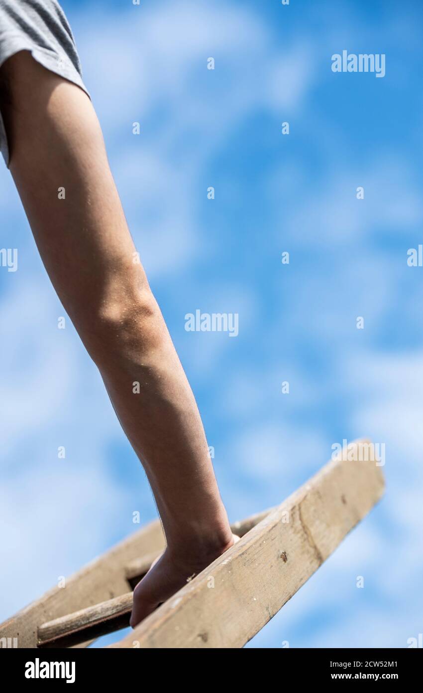 Detail of a man climbing a ladder Stock Photo