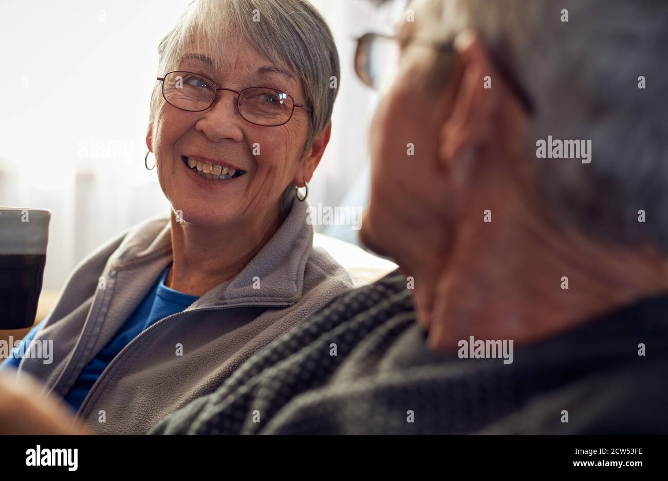 Senior Couple Relaxing And Chatting On Sofa At Home Together Stock Photo