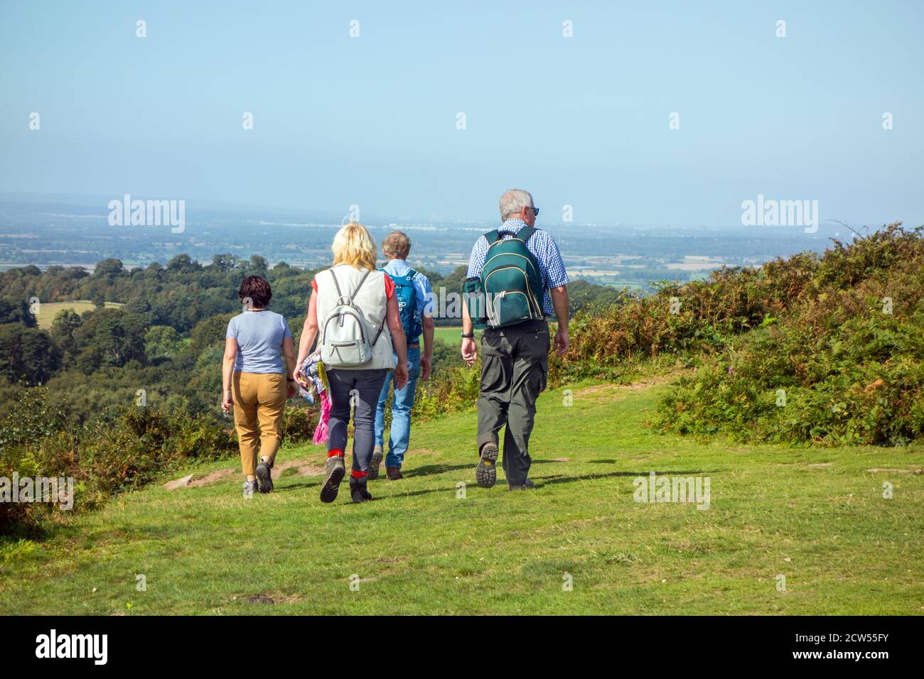 Family walking the Sandstone Trail long distance footpath on Bickerton Hills Cheshire, with a view over the Cheshire plain England Stock Photo