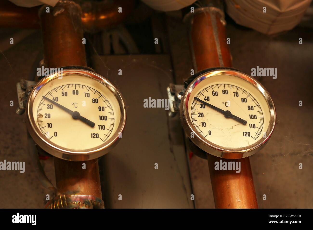 Closeup of two temperature gauges on pipes under the lights Stock Photo