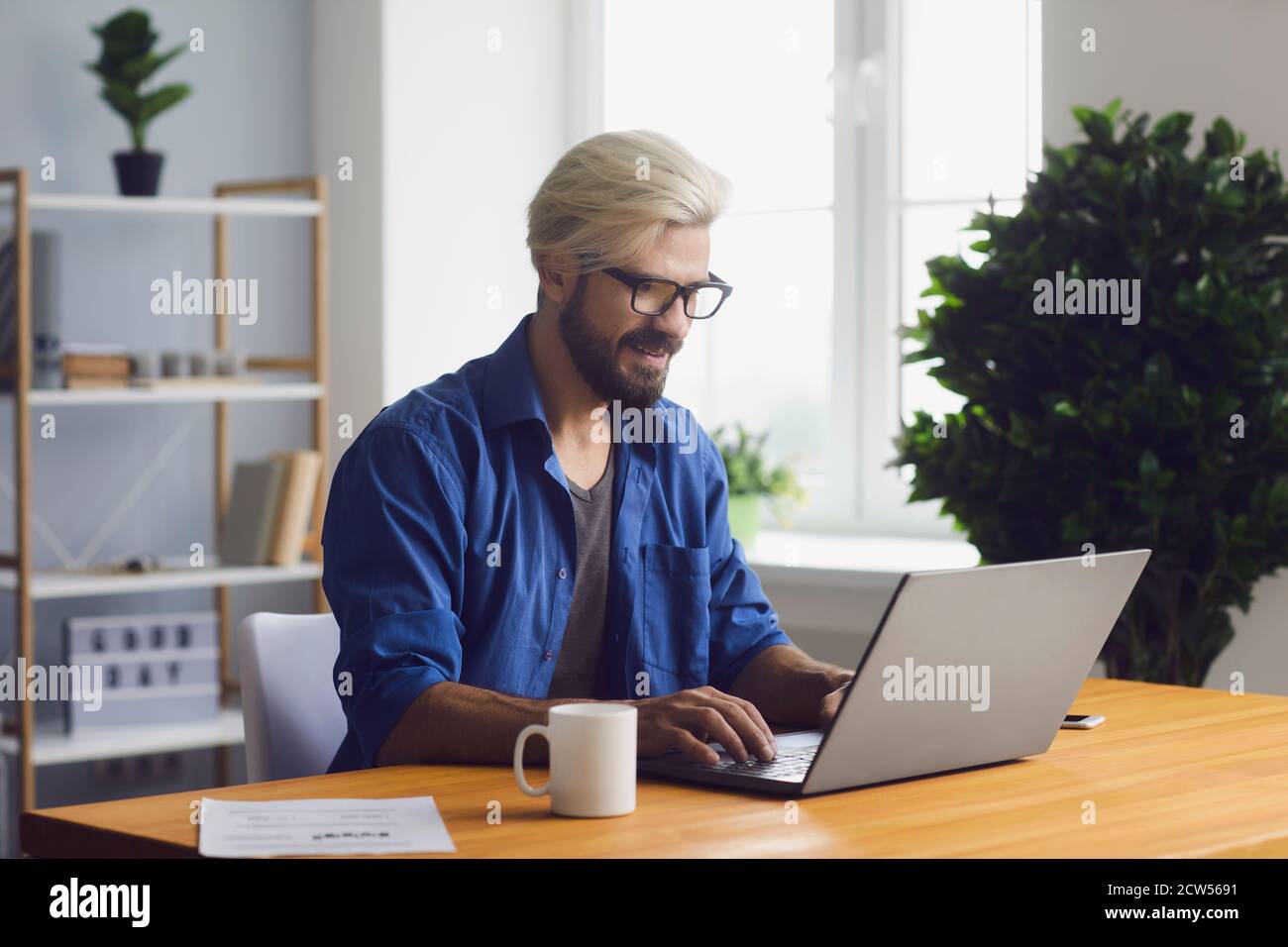 Young man working online on laptop from home Stock Photo