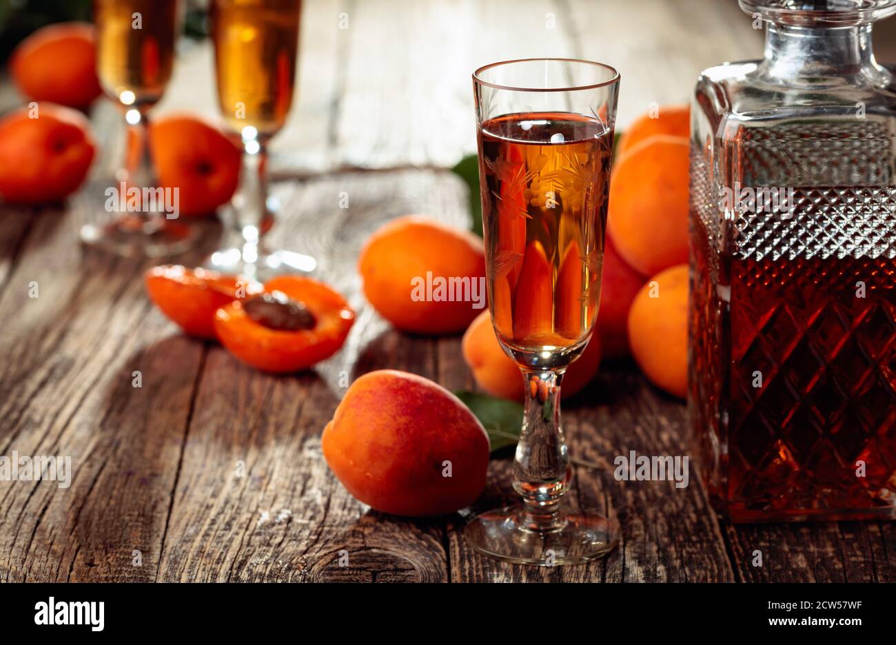 Homemade apricot liquor or grappa and fresh apricots on a old wooden ...